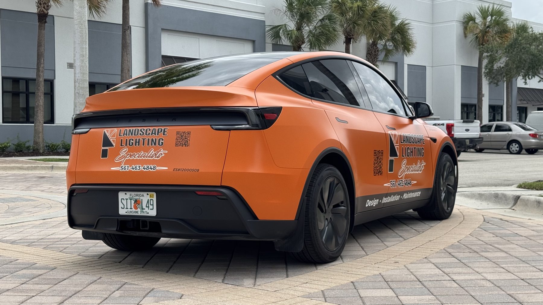 Rear three-quarter view of Landscape Lighting Specialists Tesla Model Y fleet branding