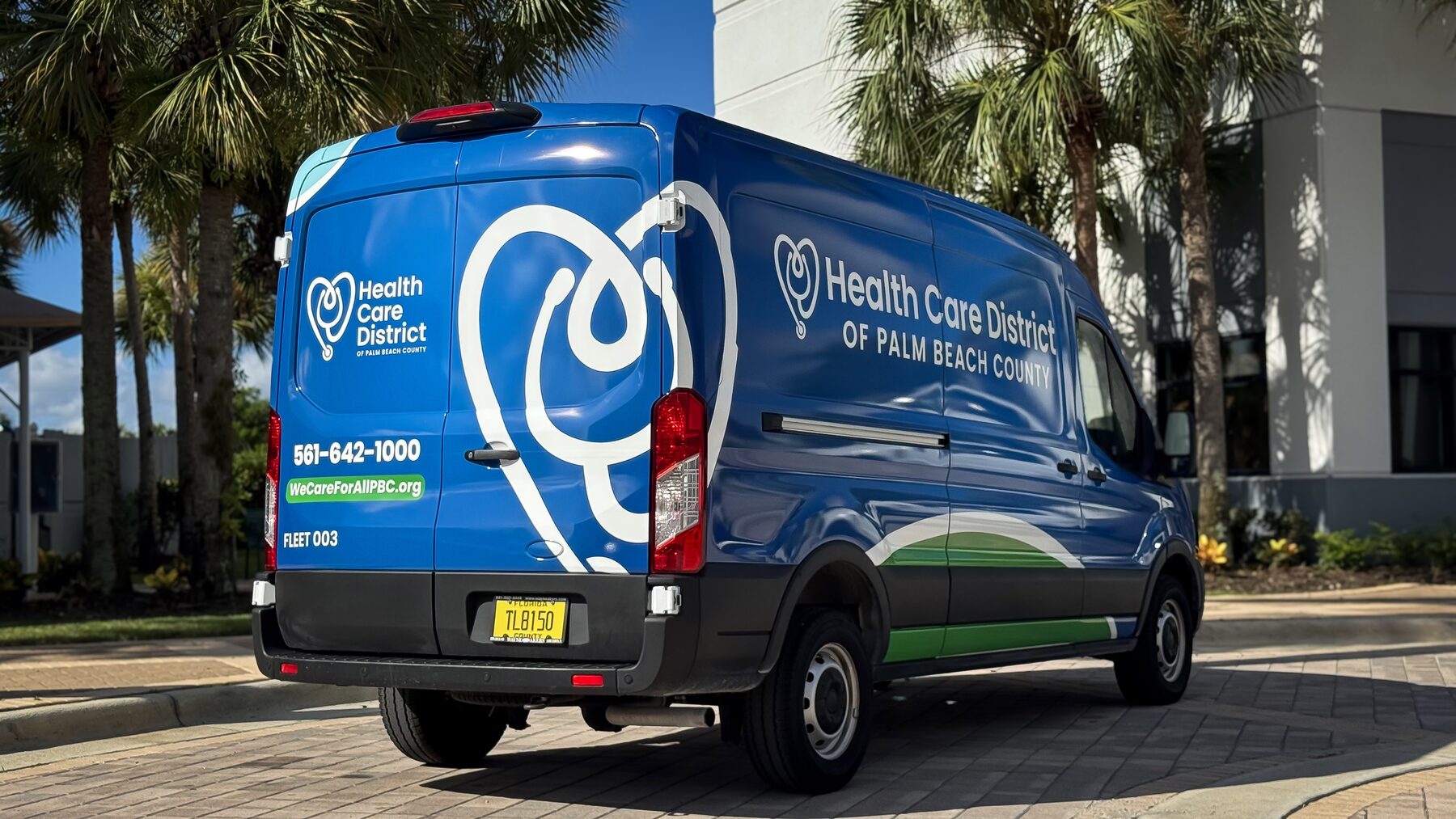 Rear and passenger-side fleet branding on a Health Care District of Palm Beach County Ford Transit