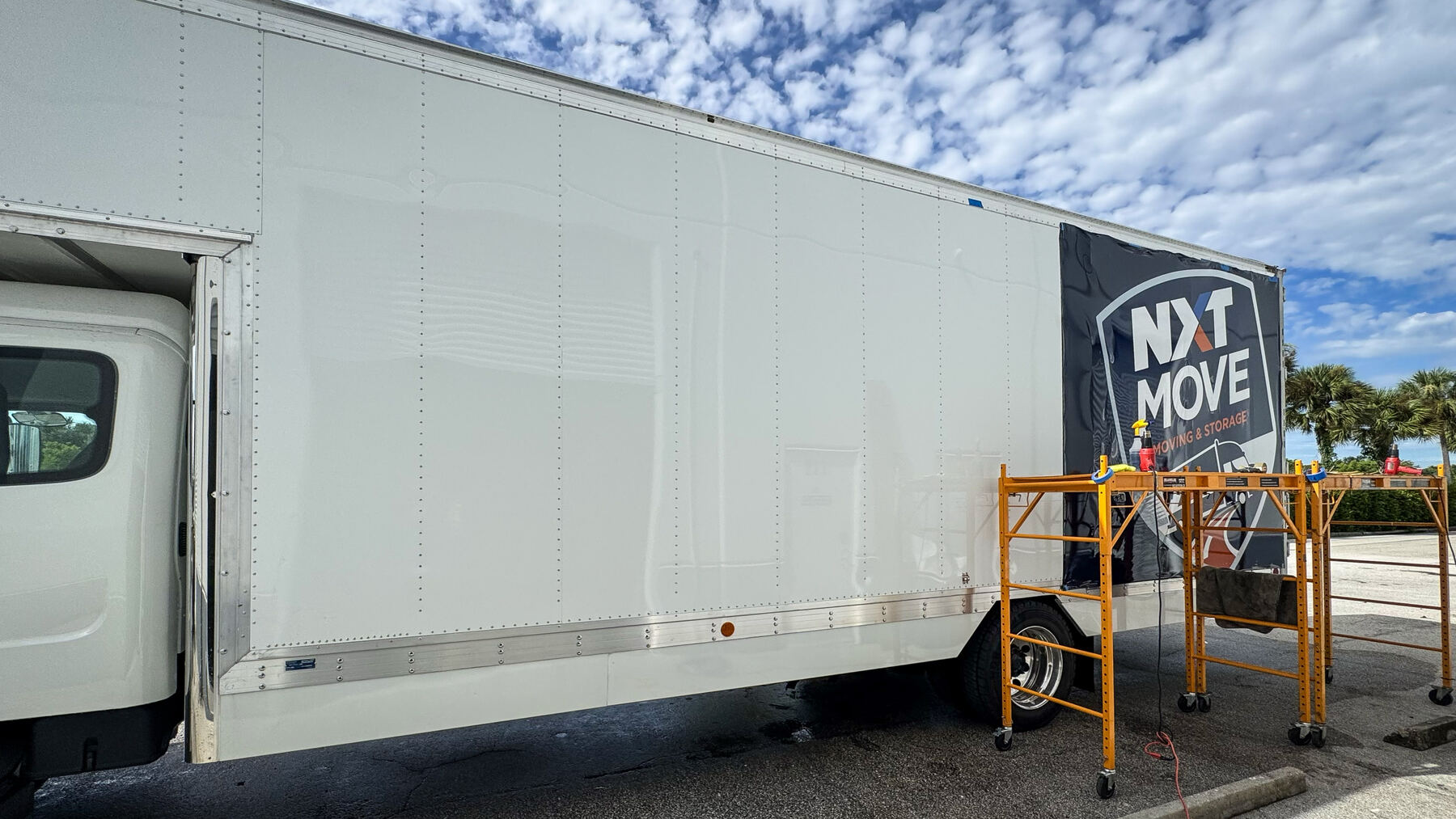 CRD Wraps installing printed graphics on a large 26-foot box truck using mobile scaffolding